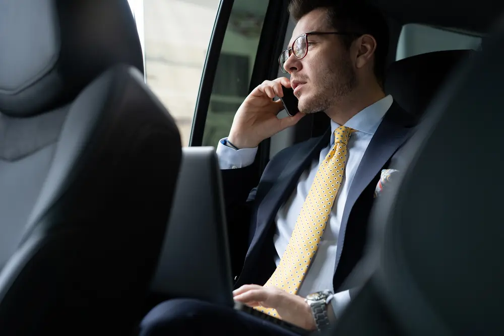 Business traveler working on laptop during intercity chauffeur service